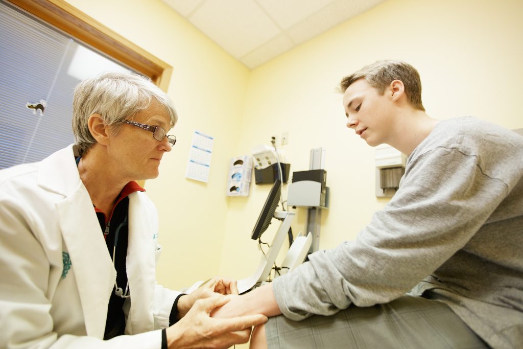Healthcare provider at CHAS Health Valley Clinic checks a patient in an exam room.