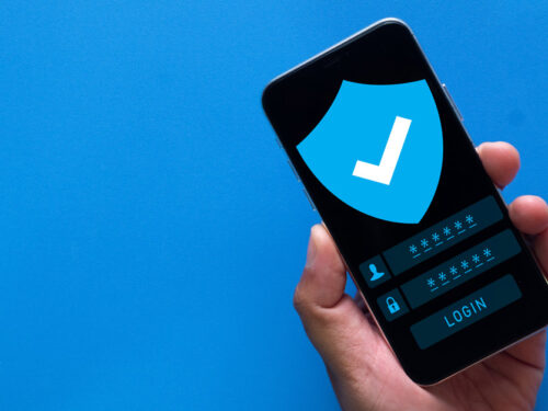 Image with a blue background showing a hand holding a cell phone with a secure login screen.