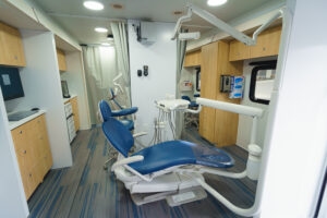 Interior of CHAS Health mobile dental clinic with an exam chair and dental equipment.