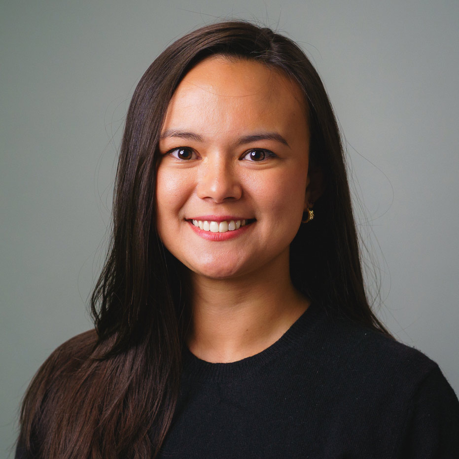 lopez-victoria Professional headshot of a person with long dark hair wearing a black top, photographed against a light gray studio background. The image is tightly framed from the shoulders up with soft, even lighting.
